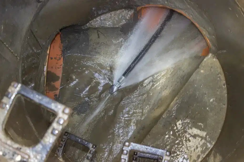 High-pressure hydro jetting nozzle cleaning the inside of a sewer pipe