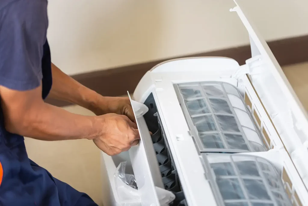 Technician opening the panel of an indoor mini-split air handler for installation