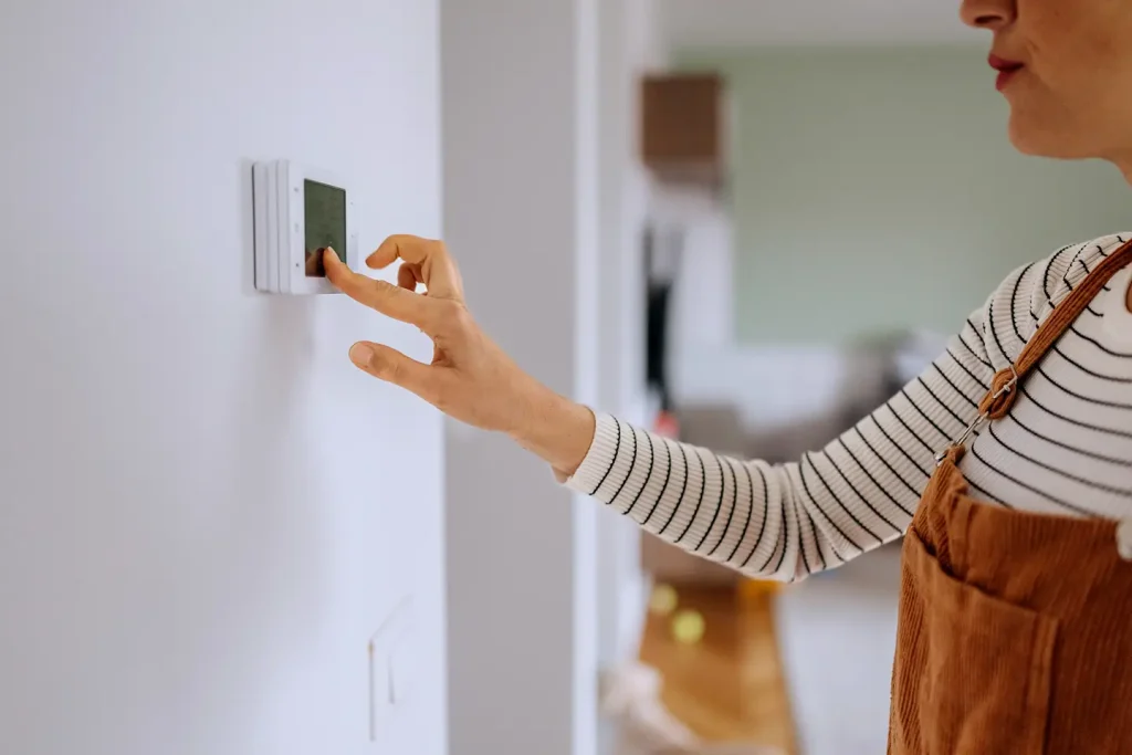 Homeowner adjusting a newly upgraded smart thermostat