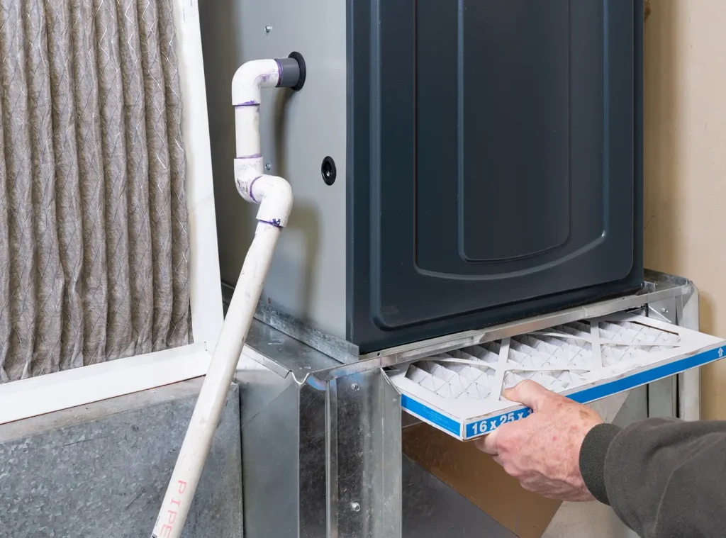 Technician installing a new furnace filter during final system setup