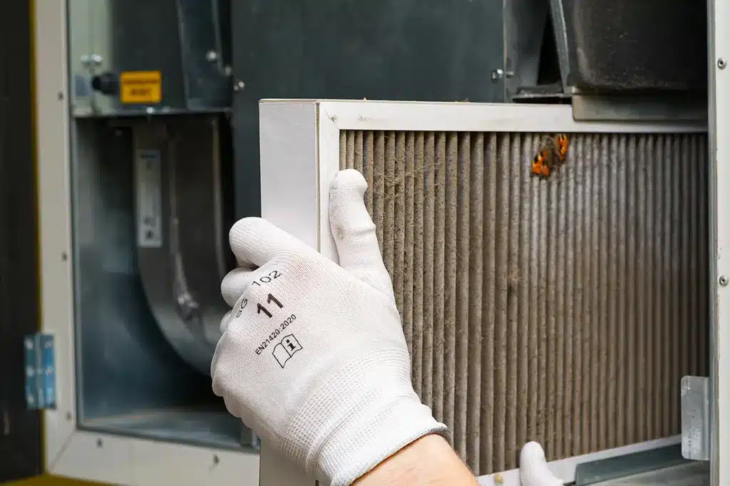 Technician inspecting a dirty furnace filter to evaluate airflow and system performance